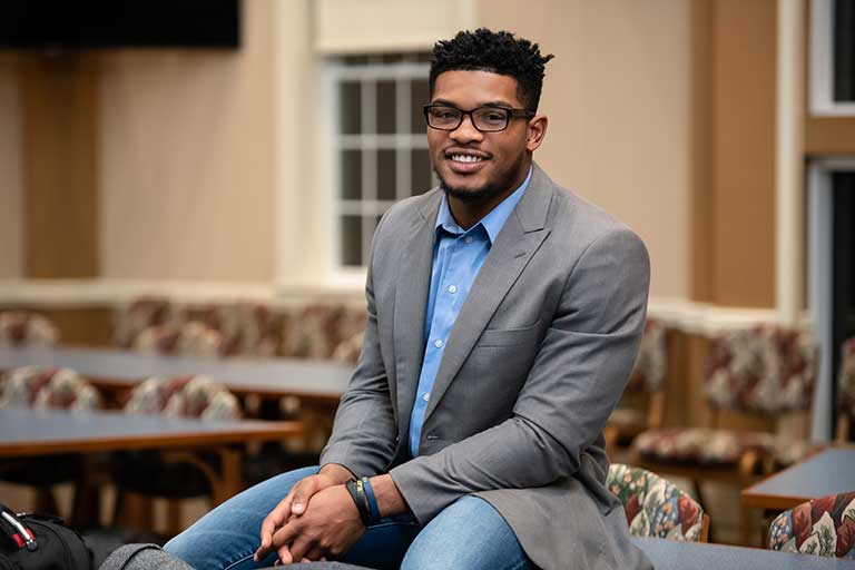 A Black student smiles for the camera.