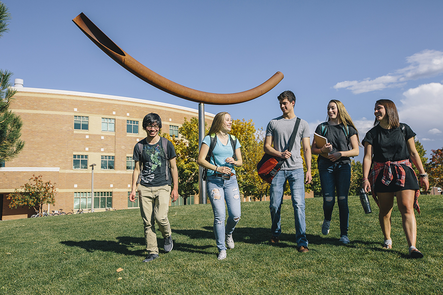 group of students walking happily across campus